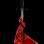 A striking still life of a medieval sword wrapped in red silk, set against a black background.